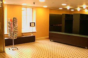 Sisätila, jossa on ruskea lattia, oranssit seinät, ikkuna ja tummat pukukaapit.