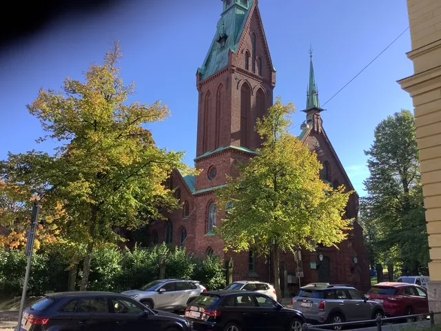 Tiilinen kirkkorakennus ja syksyiset puut